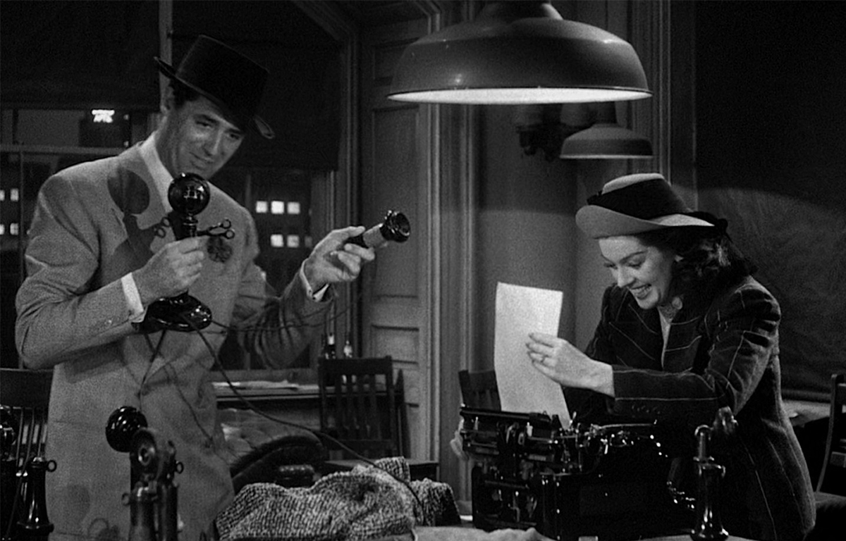 A screenshot from the movie His Girl Friday, with Cary Grant holding a telephone and Rosalind Russell using a typewriter.