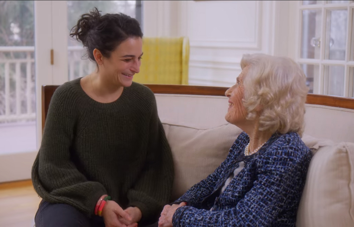 A screenshot of Jenny Slate sitting on the couch with her grandma, Nanna Connie, from Jenny's Netflix special: Stage Fright.